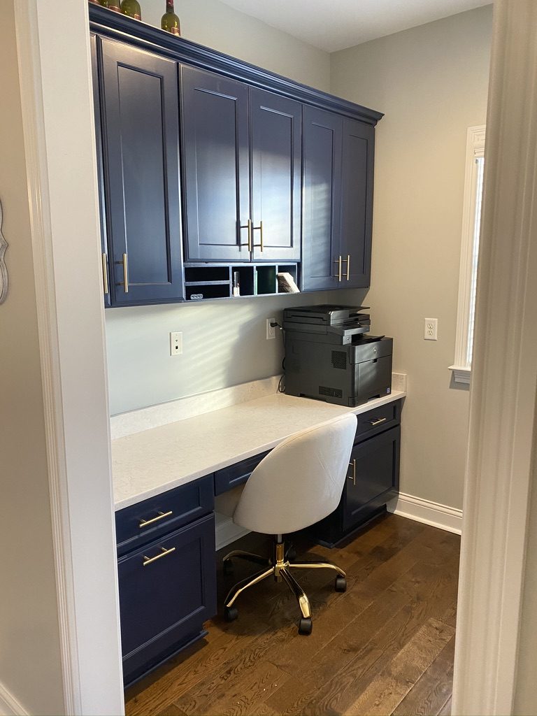 Built-in home office cabinets painted navy blue with gold pulls