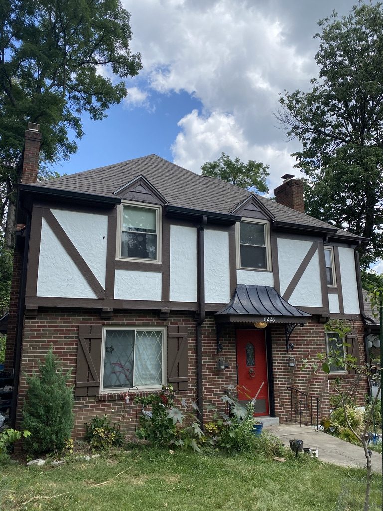 Tudor home with freshly painted white stucco and brown trim