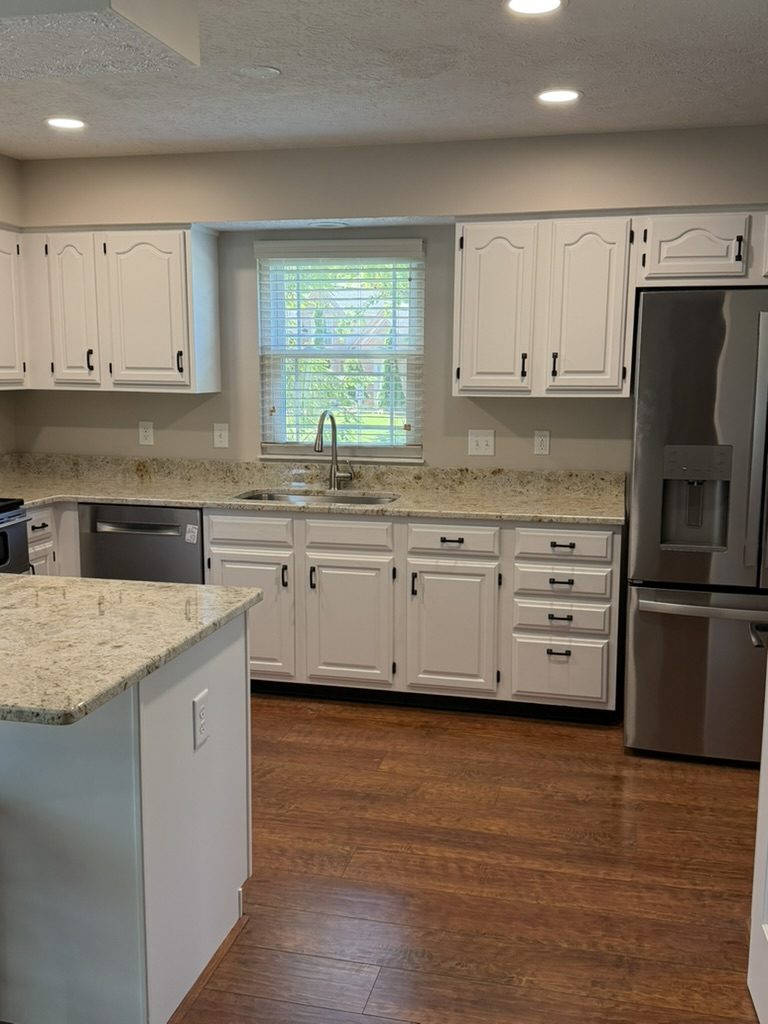 Oak kitchen cabinets refinished white with black hardware in Mason, OH