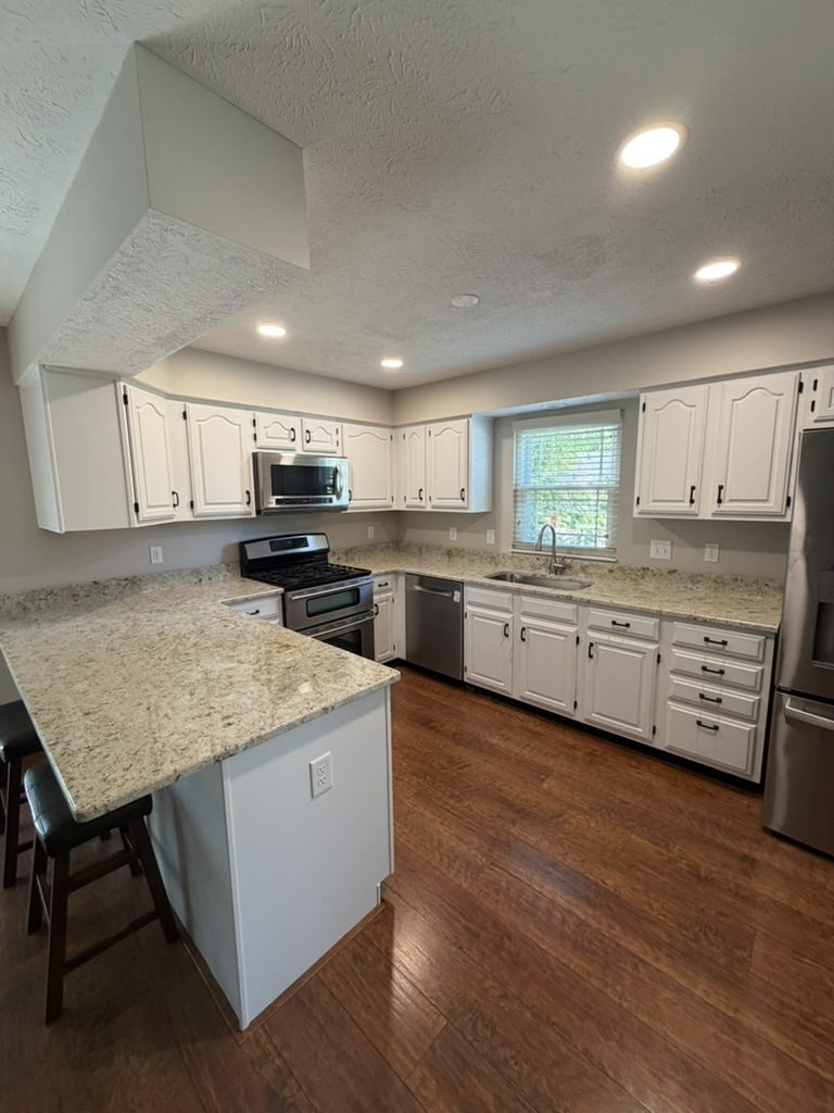 White painted kitchen cabinets and granite peninsula in Mason, OH