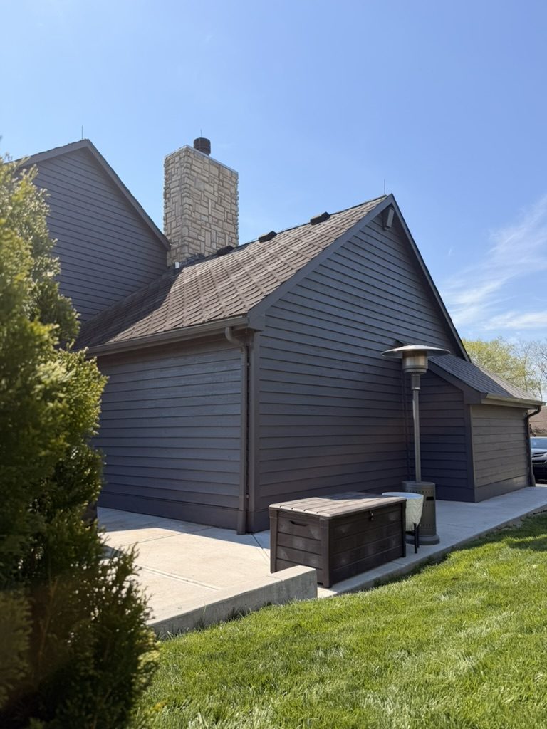 Charcoal painted siding and stone chimney on a Mason, OH home after exterior painting