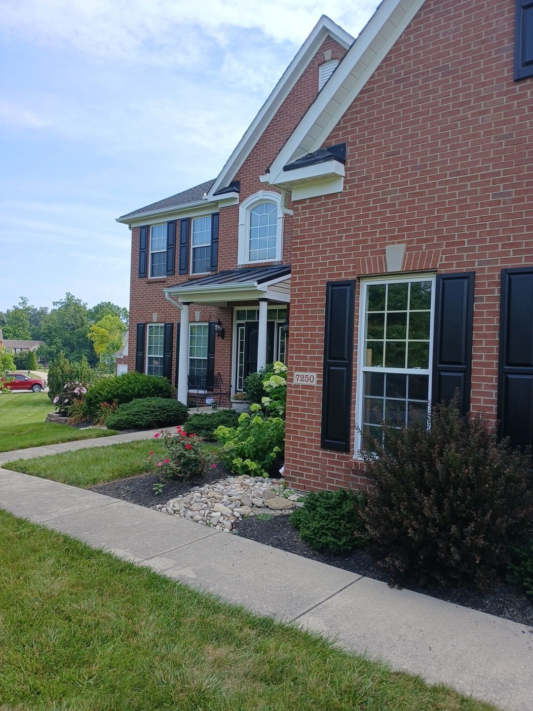 Black painted shutters and white trim on a brick home in Middletown, OH