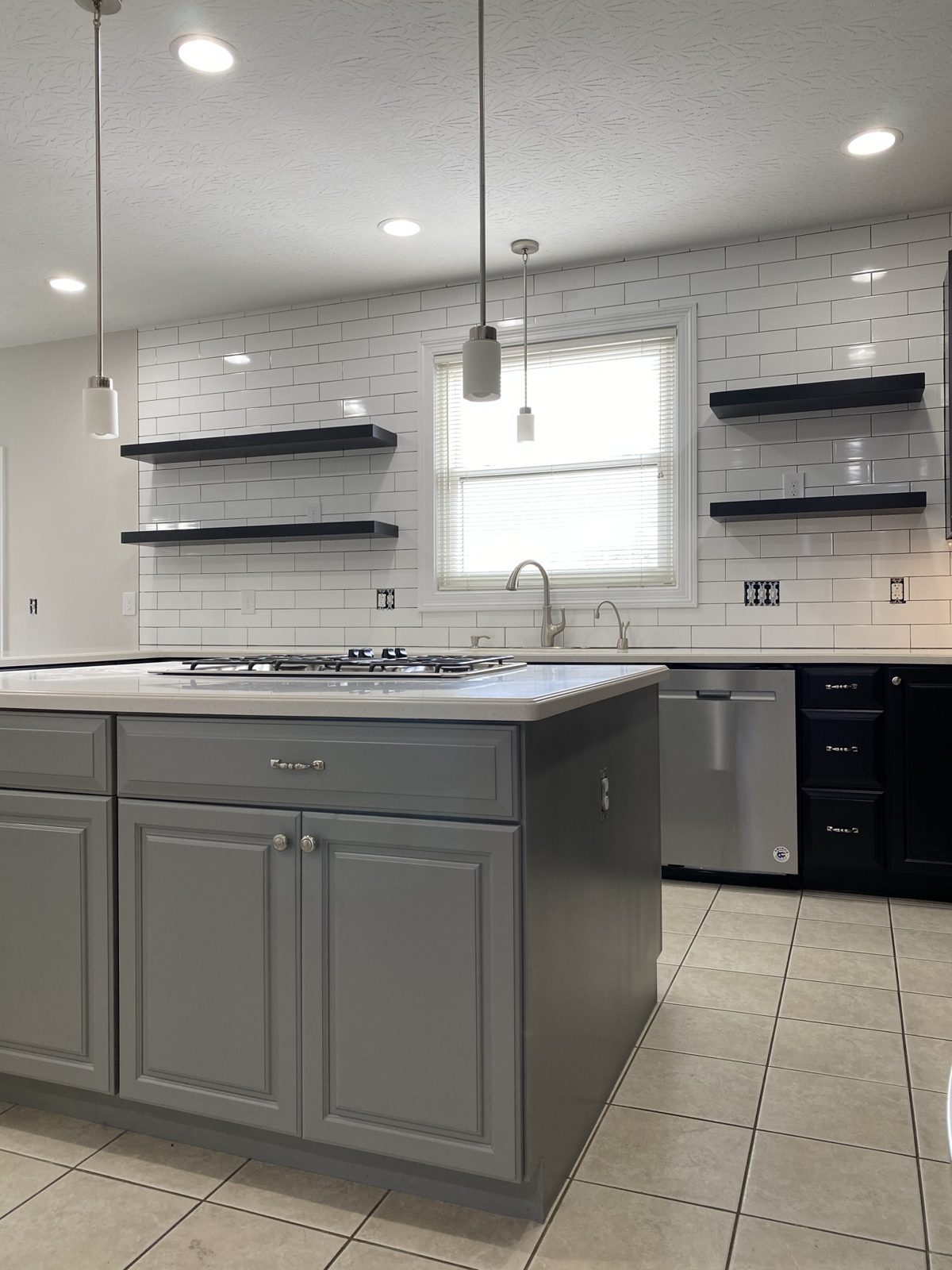 Black and gray painted kitchen cabinets with white subway tile in Monroe, OH