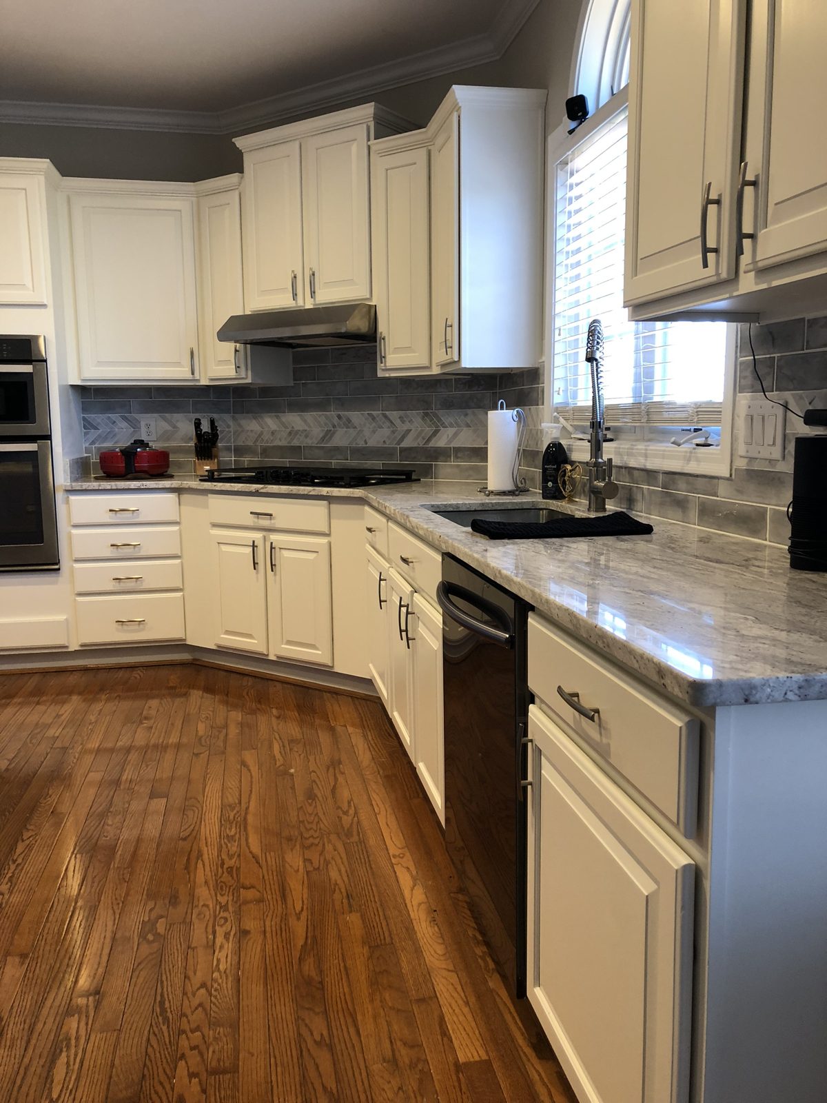 White refinished kitchen cabinets with gray marble backsplash in Monroe, OH