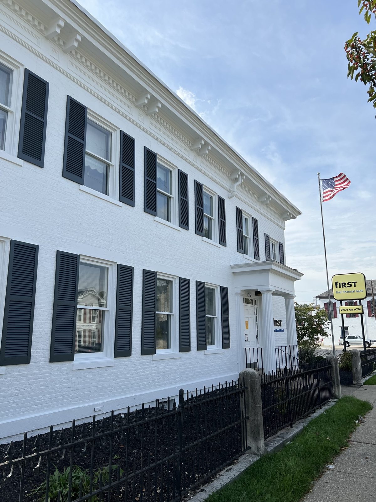 Commercial brick building painted white with new black shutters in Trenton, OH